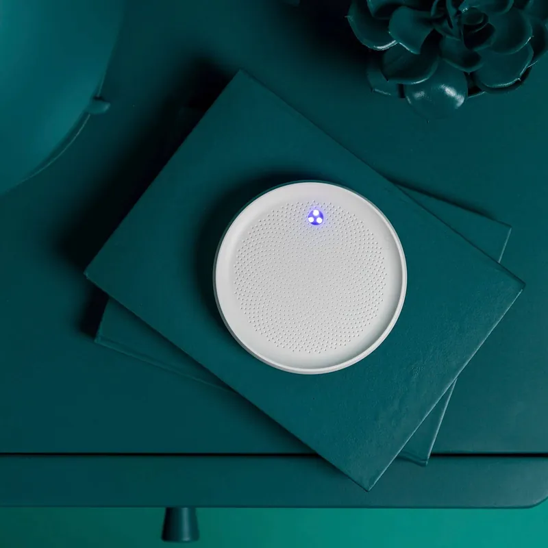 The Dodow disc resting on a dark bedside surface next to a book