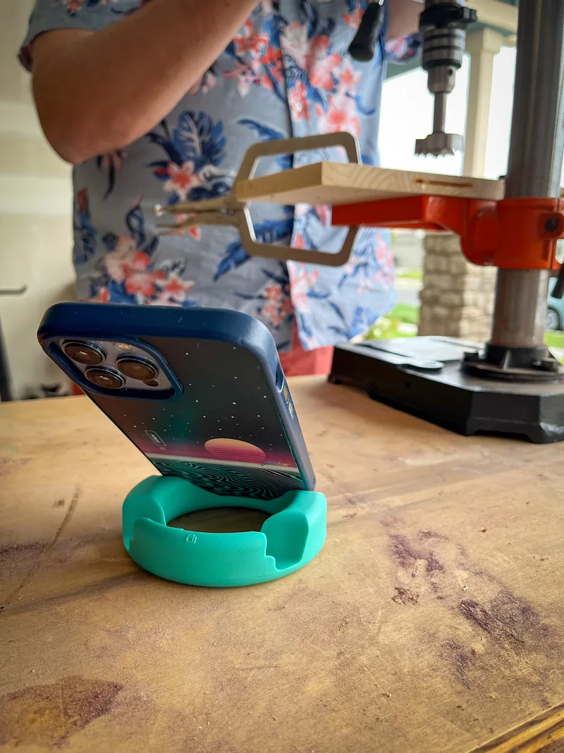 Celular encaixado no GoDonut verde-água sobre uma mesa de madeira