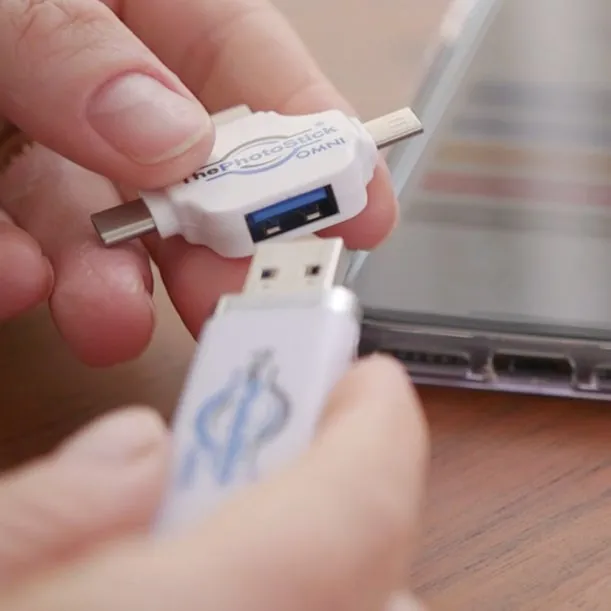 ThePhotoStick OMNI com as pontas USB-A e USB-C ao lado de um portátil
