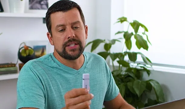 Homem segurando o ThePhotoStick OMNI enquanto fala para a câmera