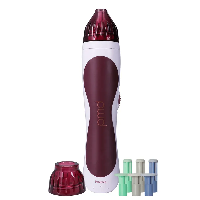 The PMD Personal Microderm Classic in berry, standing upright on a green background beside its body cap and six coloured discs