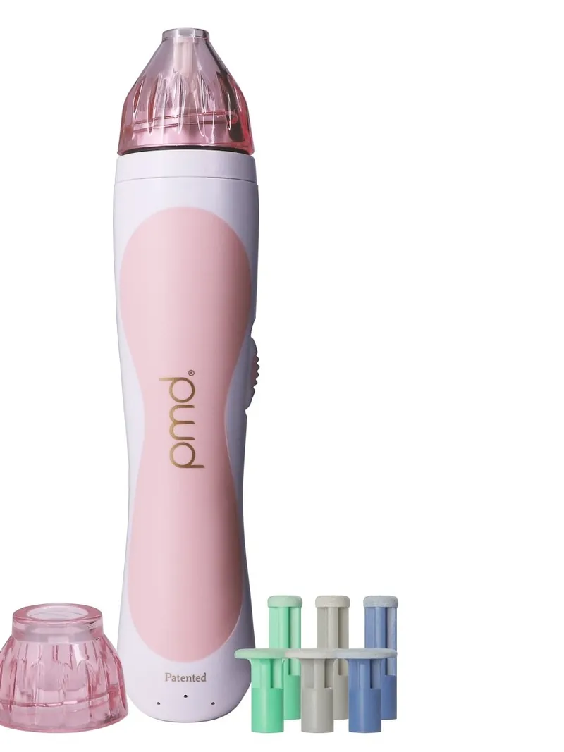 The PMD Personal Microderm in blush pink with its body cap and the six replacement discs that come with it